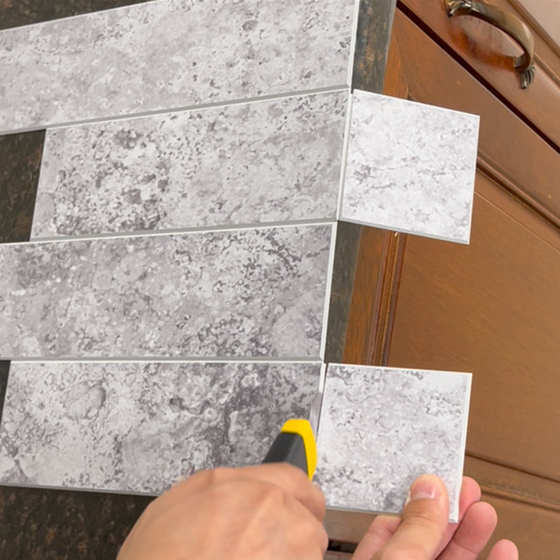 Fully separating a peel and stick backsplash tile after scoring and snapping