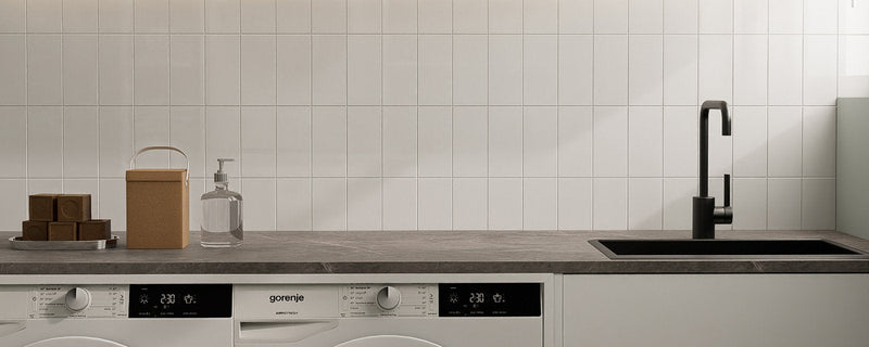 Bright laundry room with white peel and stick backsplash behind the appliances