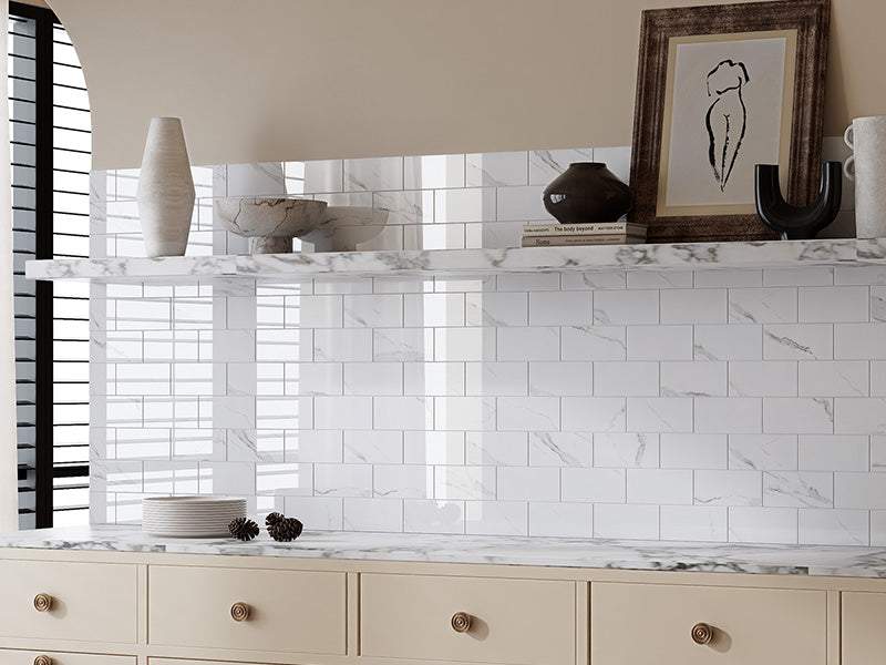 Glossy Carrara white peel and stick backsplash tiles used on a bright interior wall for a simple DIY home upgrade