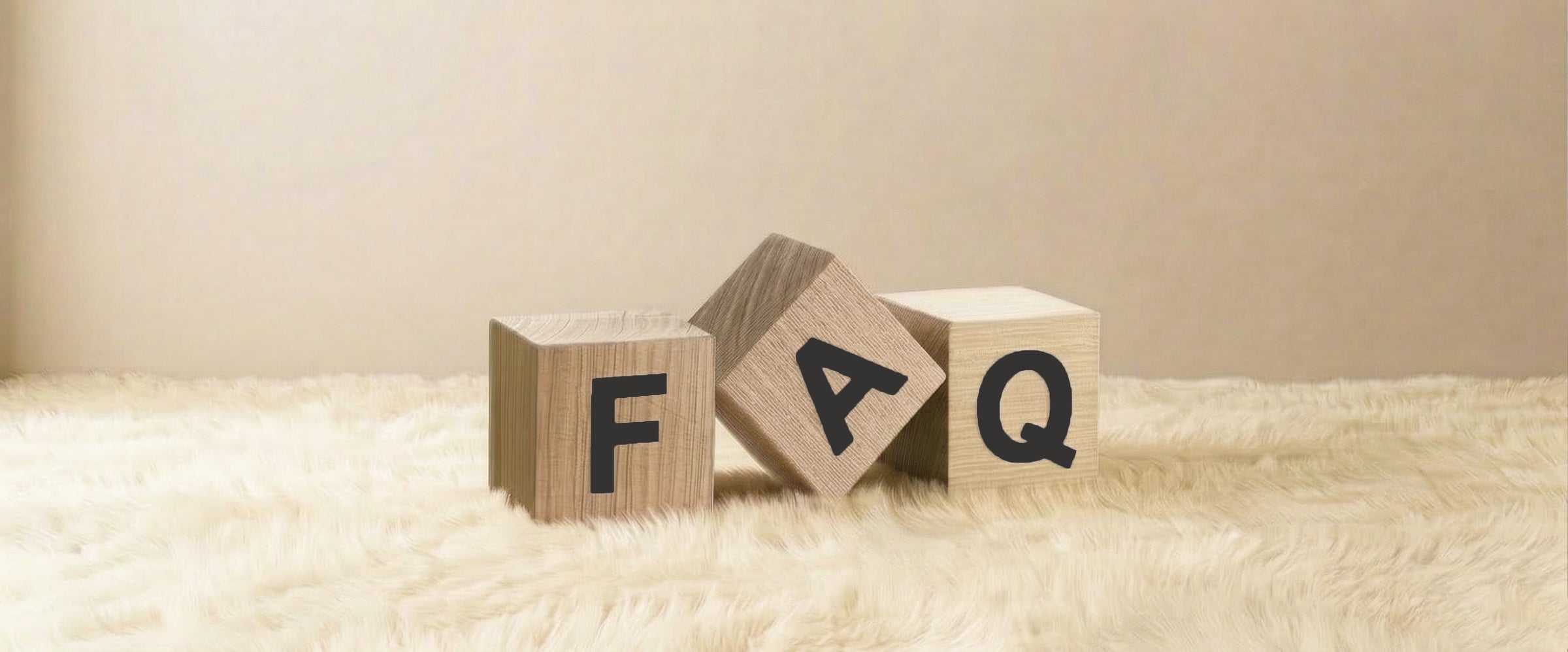 FAQ banner with wooden letter blocks spelling FAQ on a soft neutral background